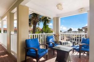 圣奥古斯丁Best Western Historic Bayfront的一个带蓝色椅子和桌子的门廊和棕榈树