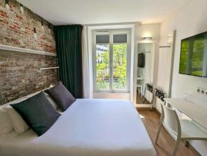 巴黎贝斯特韦斯特巴纳斯峰酒店的卧室配有白色的床和砖墙