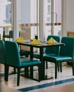 基加利Park Inn by Radisson, Kigali的一张餐桌和椅子,上面有黄色的餐巾