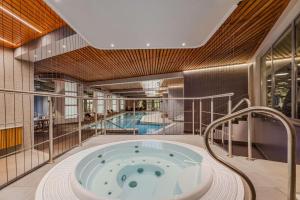 里加里加道加瓦丽笙布鲁酒店的一座带两个游泳池的建筑中的按摩浴缸