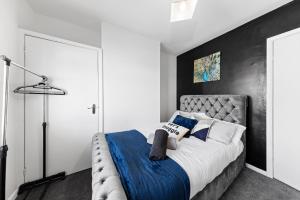 斯特鲁德Entire home in Medway, United Kingdom的一间卧室配有一张带蓝白色枕头的大床