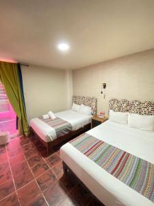 瓜达拉哈拉Hotel Flamingos的酒店客房设有两张床和窗户。