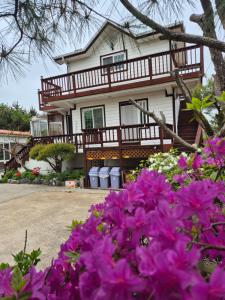 仁川市Ganghwa Sweet House Pension的前面有紫色花的房屋