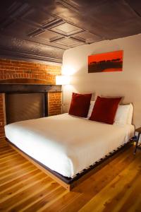 斯特吉斯The Hotel Sturgis的卧室配有带红色枕头的大型白色床