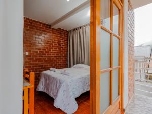 奥克萨潘帕Las Yungas Hospedaje的一间卧室设有一张床和砖墙