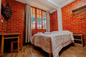 奥克萨潘帕Las Yungas Hospedaje的卧室配有砖墙内的床铺
