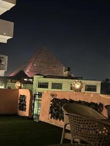开罗Beko pyramids hotel的一个带桌子和金字塔的庭院