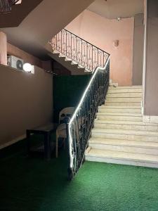 开罗Beko pyramids hotel的一套铺有绿色地毯的楼梯和一张桌子