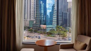 首尔LOTTE City Hotel Mapo的客房设有大窗户,享有城市美景。