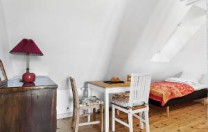 哈泽斯莱乌Amazing Home In Haderslev With Kitchen的卧室配有一张床、一张桌子和椅子