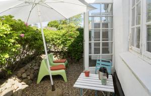 哈泽斯莱乌1 Bedroom Pet Friendly Home In Haderslev的庭院配有桌椅和遮阳伞。
