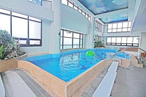 马尼拉BSA双子塔酒店的一座大型游泳池,位于一座带窗户的建筑内