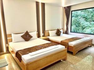 吉婆岛Cat Ba Rose Nhung Hotel的一间卧室设有两张床和大窗户