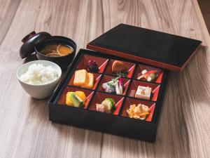 东京Hotel Rilassare Tokyo的一盒寿司和一碗米饭