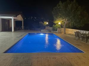 帕福斯Beautiful Home的夜晚在院子里的一个蓝色游泳池