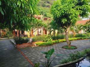 宁平Ninh Binh Mountain Side Homestay & Cafe的一座有树和砖路的花园