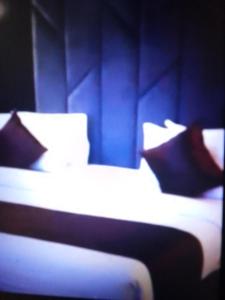 哈科特港Villa toscana luxe hotel port Harcourt的蓝色客房中的两张床和枕头