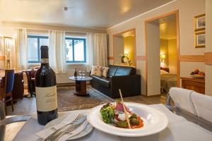 纳姆索斯蒂诺酒店的一瓶葡萄酒和一盘桌上的食物