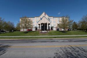 哈里斯堡Country Inn & Suites by Radisson, Harrisburg - Hershey West, PA的一座白色的大建筑,前方有钟