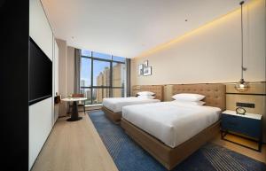 成都成都高新会展中心福朋喜来登酒店的酒店客房设有两张床和一台平面电视。