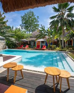 邦劳卡萨蒂亚别墅度假酒店的一座房子旁的游泳池,配有两把桌子和椅子