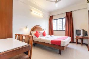 班加罗尔OYO Hotel Sunil Residency的一间酒店客房,配有一张床和一台电视