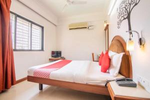 班加罗尔OYO Hotel Sunil Residency的一间卧室配有一张床、一张书桌和一个窗户。
