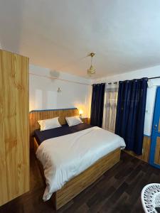 马拉里Tiny Spot Hostel的一间卧室配有一张带蓝色窗帘的大床