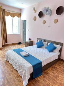 吉婆岛NA NA Homestay的一间卧室配有一张带蓝色枕头的大床