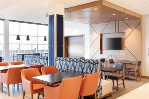 洛根霍金希尔斯 - 洛根智选假日酒店的用餐室配有桌椅和平面电视。