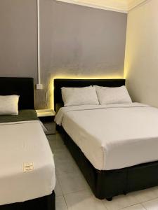 哥打巴鲁Andiana Hotel & Lodge - Kota Bharu City Centre的配有两张床垫的酒店客房内的两张床