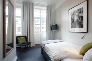 厄勒布鲁Hotel Örebro的酒店的客房 - 带一张床、椅子和窗户
