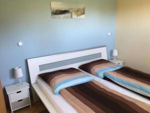 普鲁滕Boddensurfer 2b Comfortable holiday residence的一间卧室设有两张床和蓝色的墙壁
