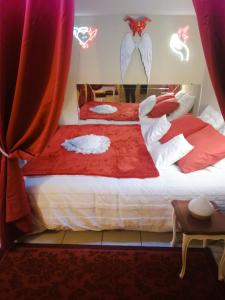 AulnatLove Room Ange ou Démon à Aulnat的一间卧室配有两张红色和白色床单