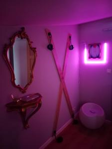 AulnatLove Room Ange ou Démon à Aulnat的浴室设有粉红色的灯光、镜子和卫生间
