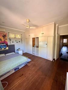 珀斯Chimu Home-Hostel的一间大卧室,配有一张床和一个吊扇