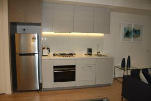 悉尼Perfect large one bedroom plus study - ALB09518的厨房配有白色橱柜和不锈钢冰箱