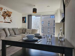 米尔顿凯恩斯Luxury 1-Bed Apartment with balcony & Free parking的客厅配有桌子和沙发