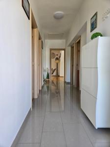 克尔克Apartmani Pavlović的走廊设有白色墙壁和白色冰箱