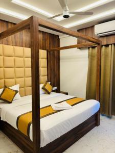 那格浦尔Airport Hotel Relax Inn的一间卧室配有一张木架床
