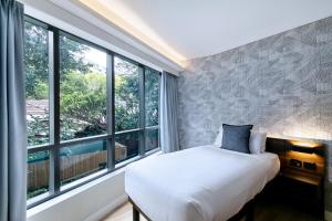 悉尼Kith Hotel Darling Harbour的一间卧室设有一张床和一个大窗户