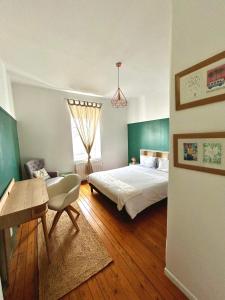 勒芒Appartements Plantagenet - Le 33的一间卧室配有一张床、一张桌子和一张书桌