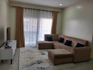 坎帕拉FG Homestay, Kampala Muyenga-Bukasa的带沙发和大窗户的客厅