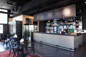 苏黎世VISIONAPARTMENTS Wolframplatz - contactless check-in的餐厅内的酒吧配有桌椅
