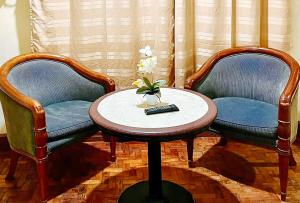 达古潘RedDoorz @ Tondaligan Beach Hotel的两张椅子和一张桌子,上面有遥控器