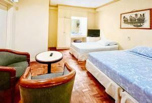 达古潘RedDoorz @ Tondaligan Beach Hotel的酒店客房设有两张床和一张桌子。