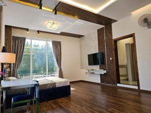 阿吉曼(Anushthan Villa) serviced villa for staycation的一间卧室配有一张床、一张书桌和一台电视