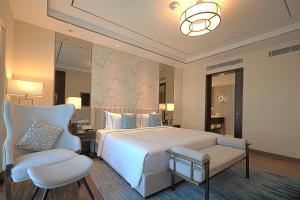 德瓦纳哈利-班加罗尔班加罗尔泰伊酒店的卧室配有白色的床和椅子