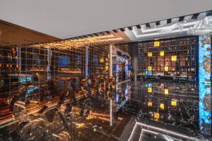 特里科莫Grand Sapphire Resort & Casino的建筑中带玻璃墙和灯的酒吧
