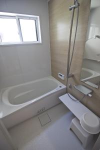 京都Gion House的白色的浴室设有浴缸和水槽。